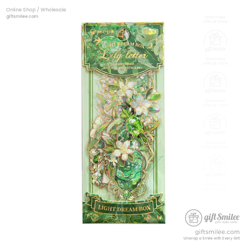 Close-up of a green Light Dream Box sticker pack showcasing intricate lily designs and gold accents