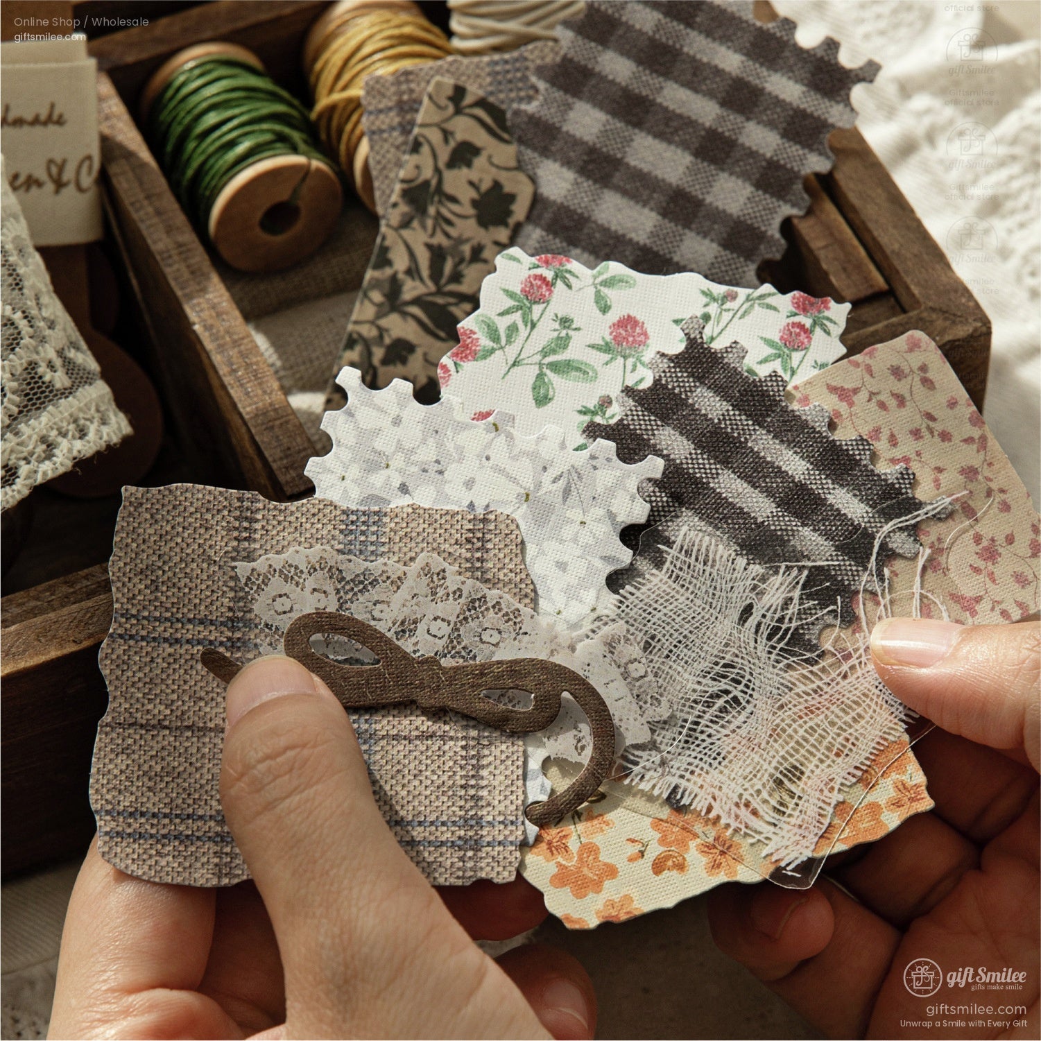 Hands holding rustic fabric and floral-patterned scrapbook pieces, ideal for DIY crafting