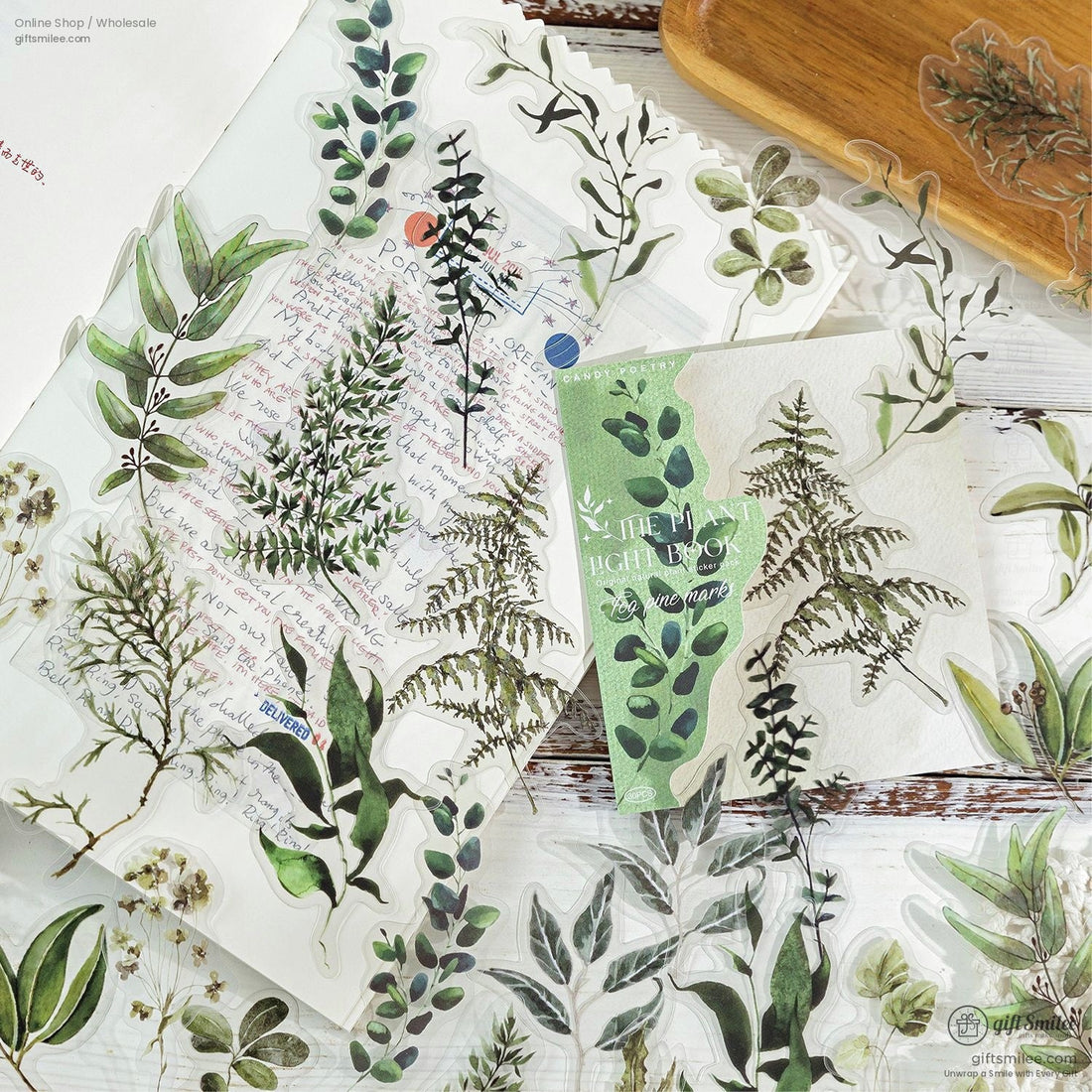 Rustic botanical sticker collection featuring various green leafy designs on a wooden table