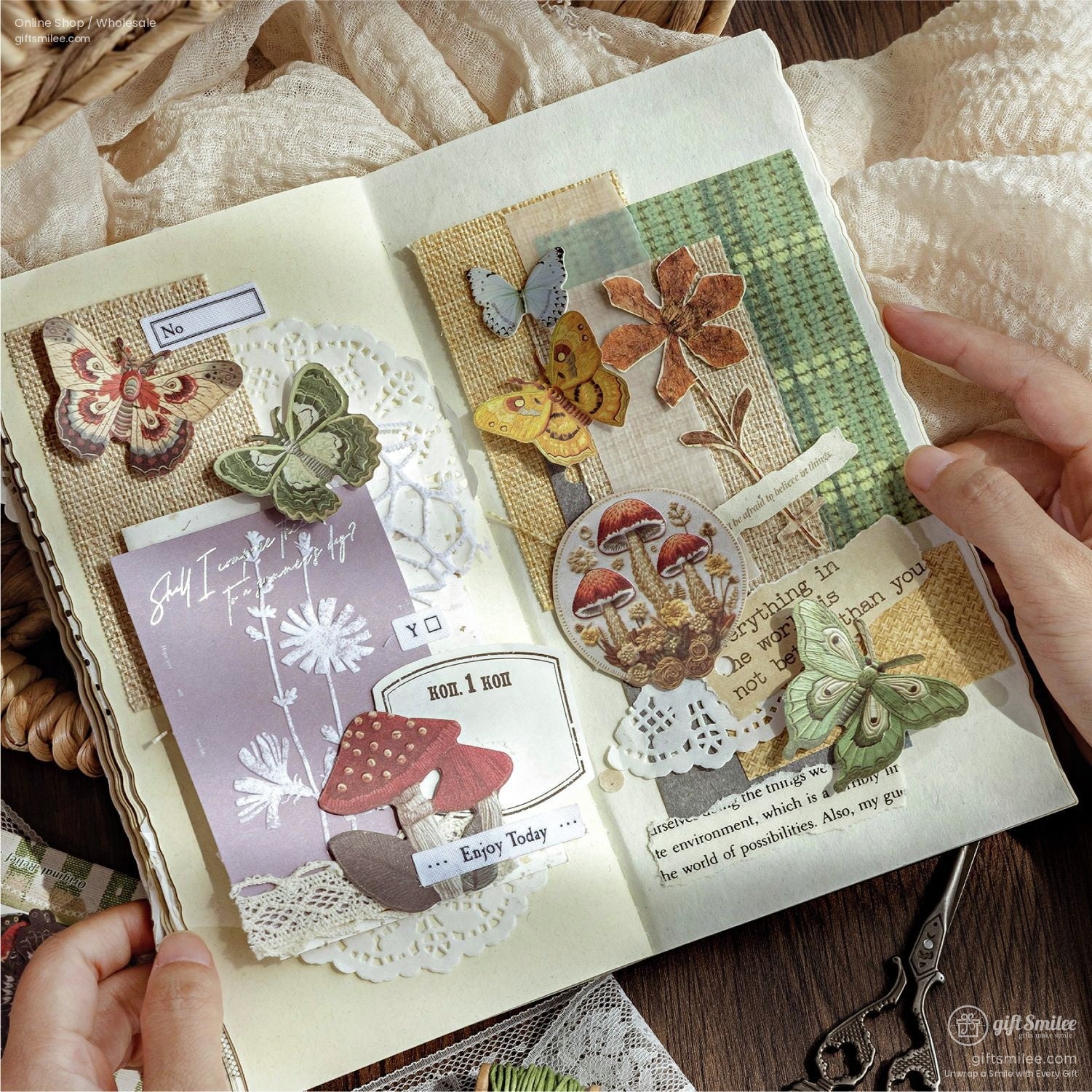 A scrapbook page featuring butterfly and mushroom cutouts, arranged with lace and textured paper for journaling