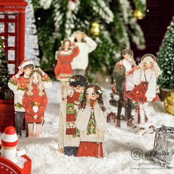 Romantic couple stickers in cozy Christmas outfits displayed on snowy holiday decor