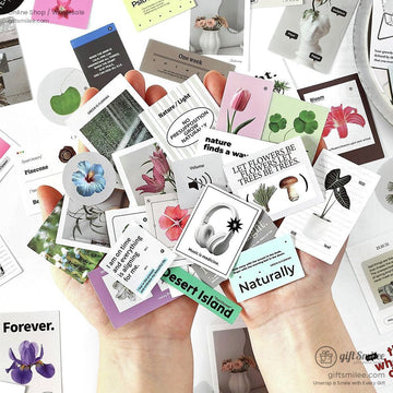 Hands holding botanical and floral aesthetic stickers, featuring flowers, plants, and motivational quotes