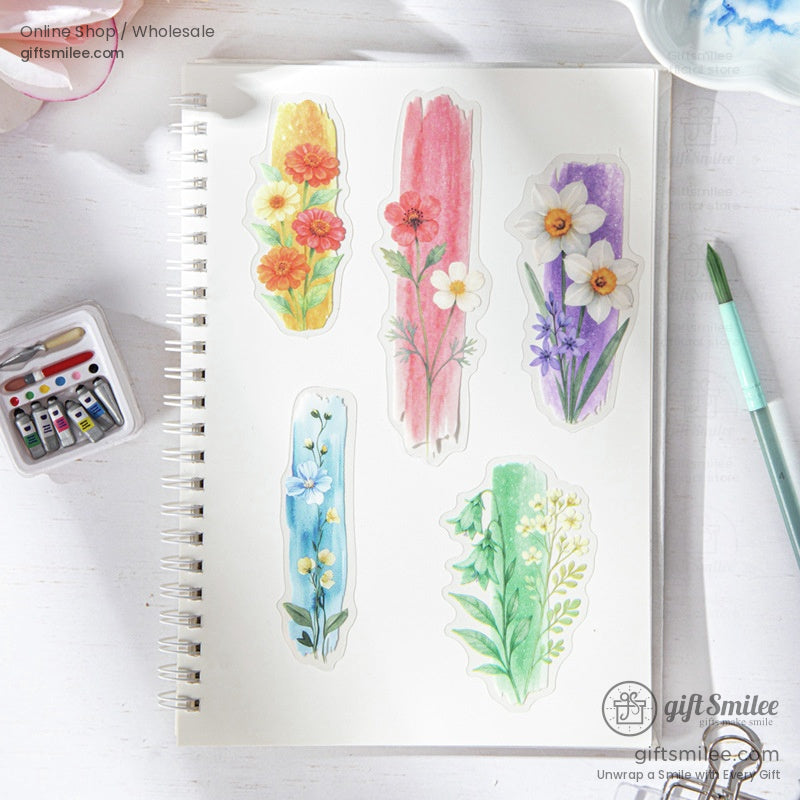 A notebook decorated with colorful ink-dyed floral stickers, including daisies and poppies