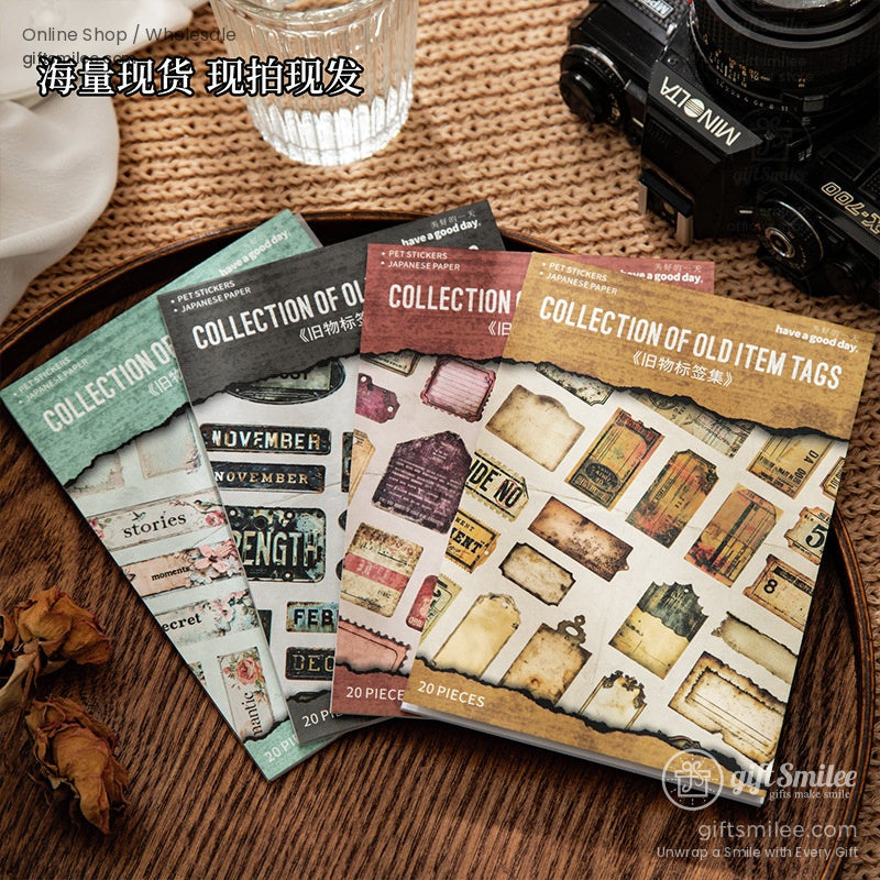 Four packs of vintage sticker sets laid on a rustic table, showcasing decorative tags for journaling and scrapbooking