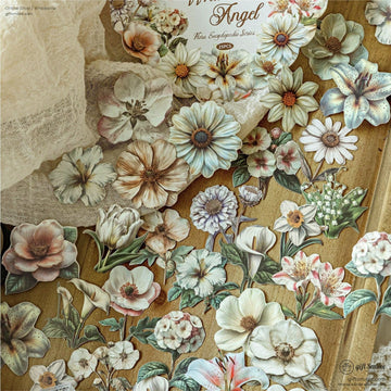Vintage floral stickers with soft pastel hues on a wooden background