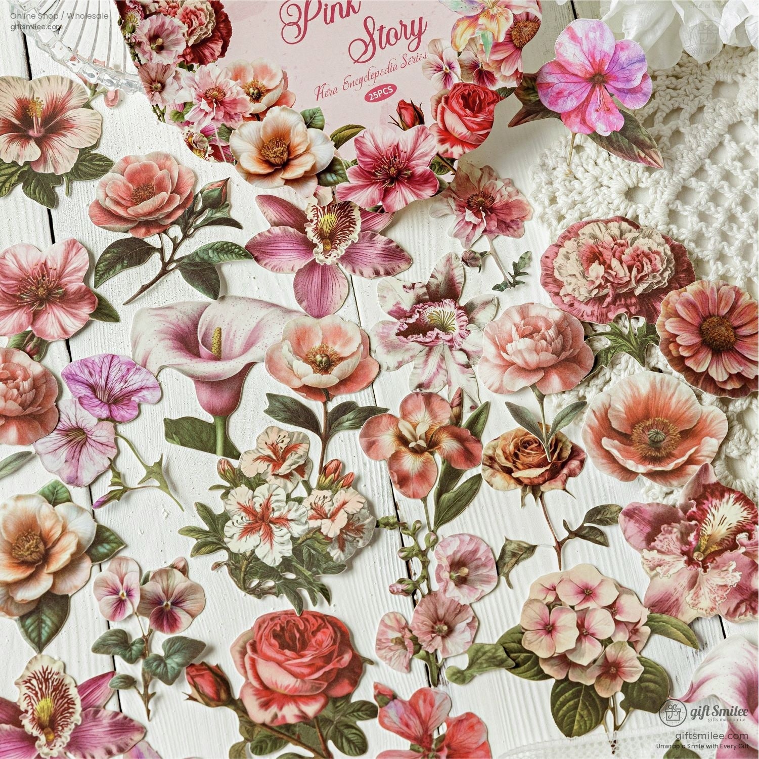 Pink and blush-toned flower stickers arranged elegantly on a white lace background