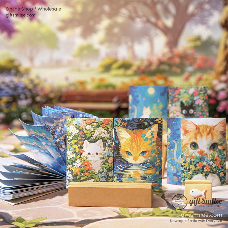 Mini cat-themed journals displayed outdoors on a wooden stand surrounded by a peaceful garden scene