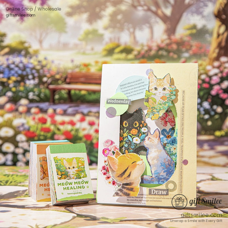 Artistic arrangement of Meow Meow Healing journals alongside a creative cutout cat-themed card with floral accents
