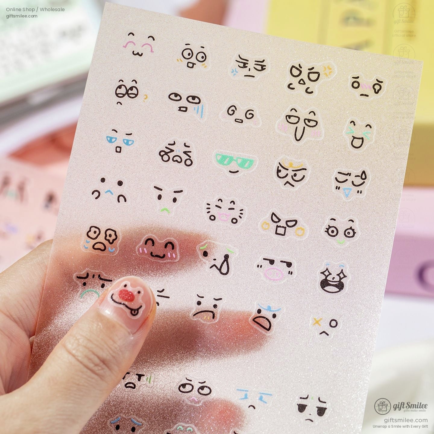 Hand holding a sheet of kawaii stickers showcasing vibrant and expressive cartoon faces
