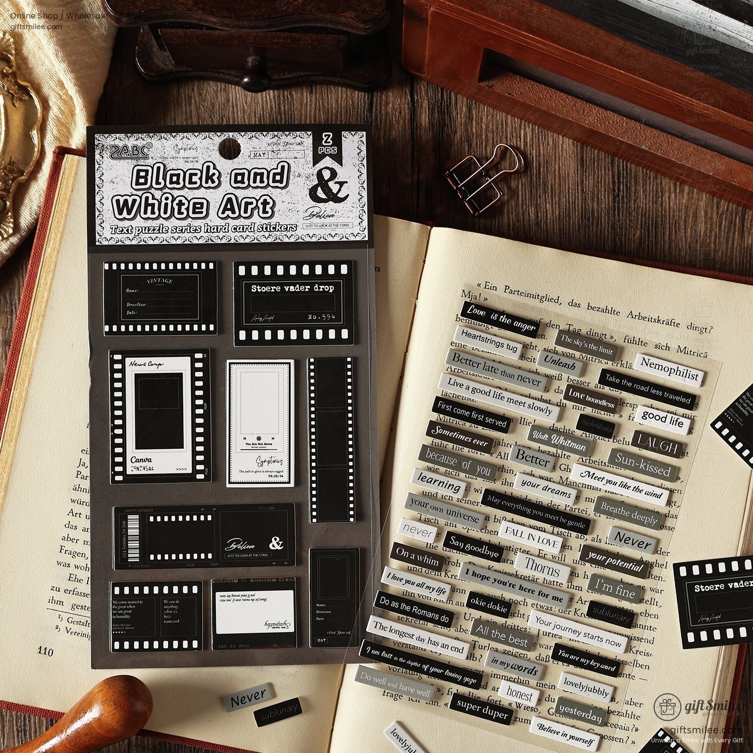 Black and white art stickers for journals, shown on an open book with decorative clips
