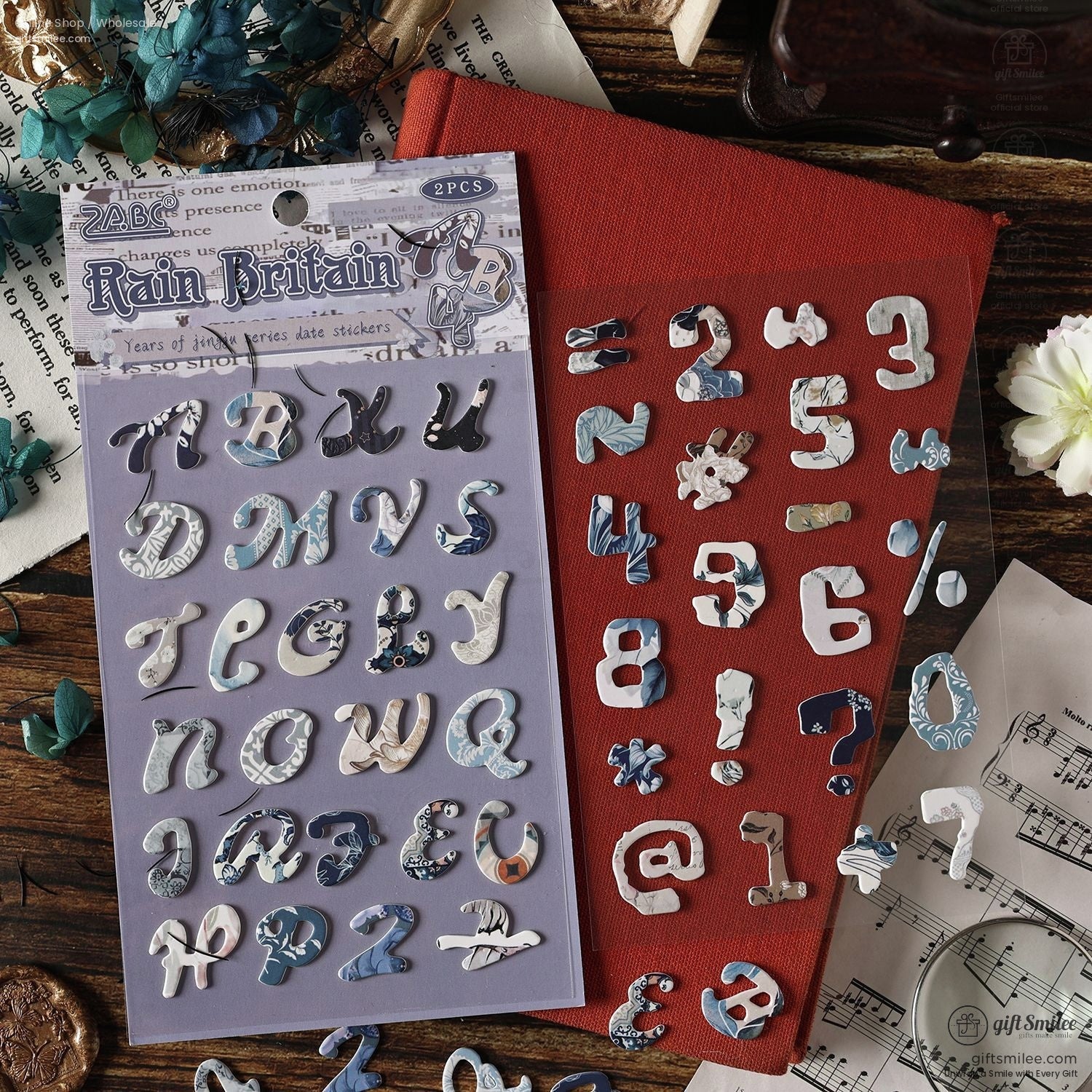 Close-up of the Rain Britain vintage alphabet stickers placed alongside numbers and symbols on a red journal