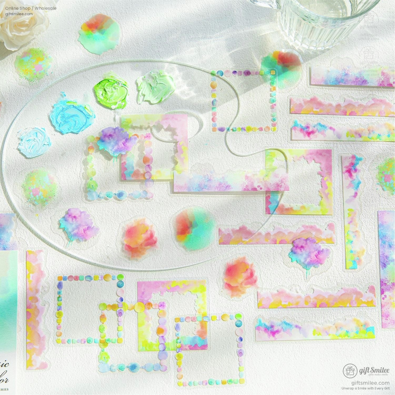Close-up view of pastel and watercolor-themed stickers laid out with vibrant artistic tools