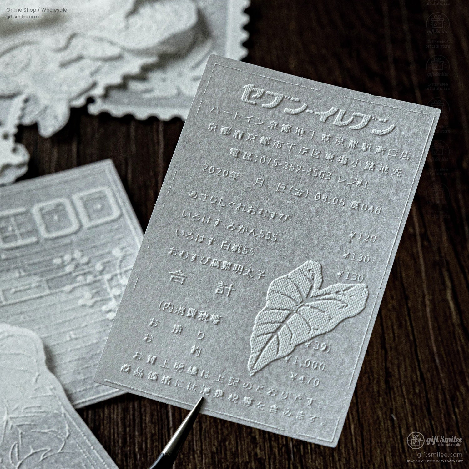 Detailed view of a single embossed sticker with intricate leaf patterns and text