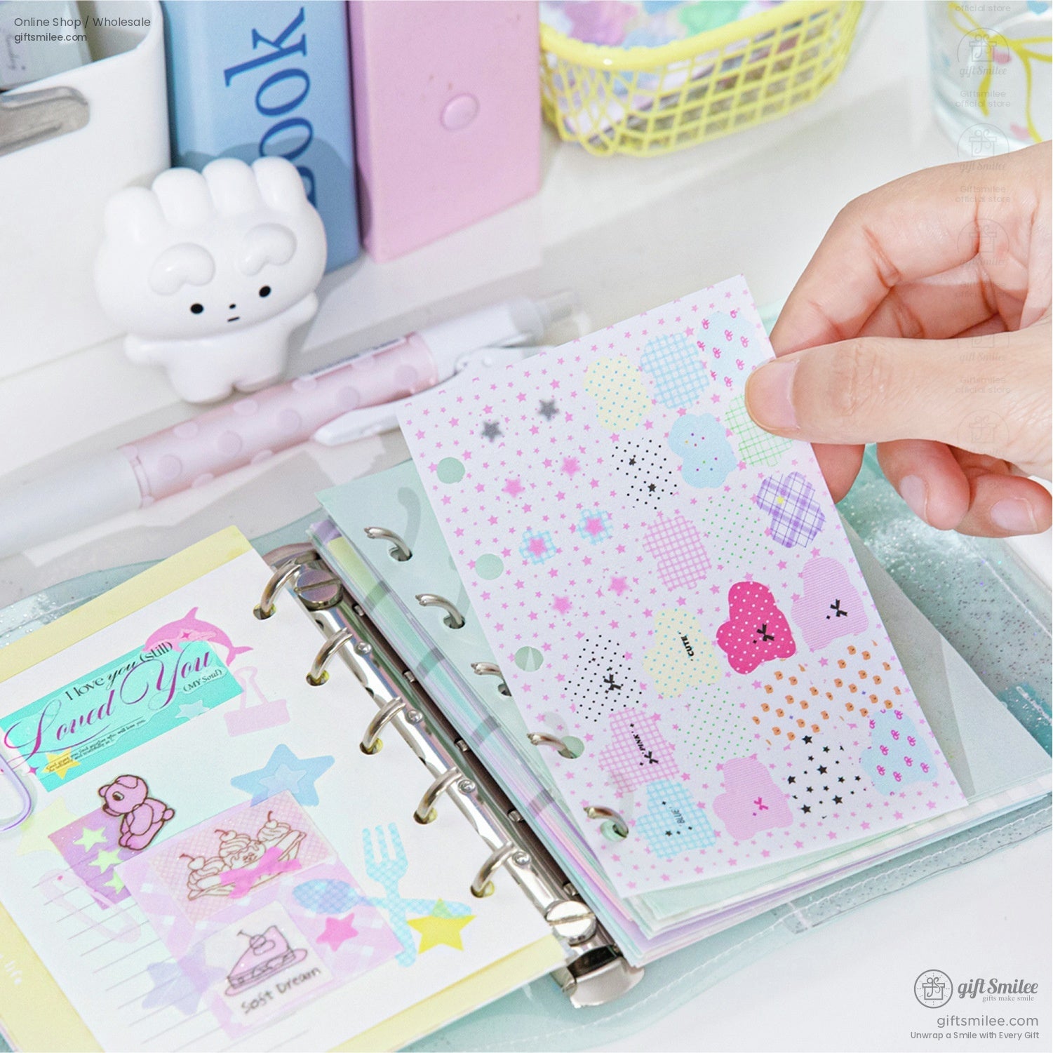 A person flipping through pastel and patterned stickers in a planner
