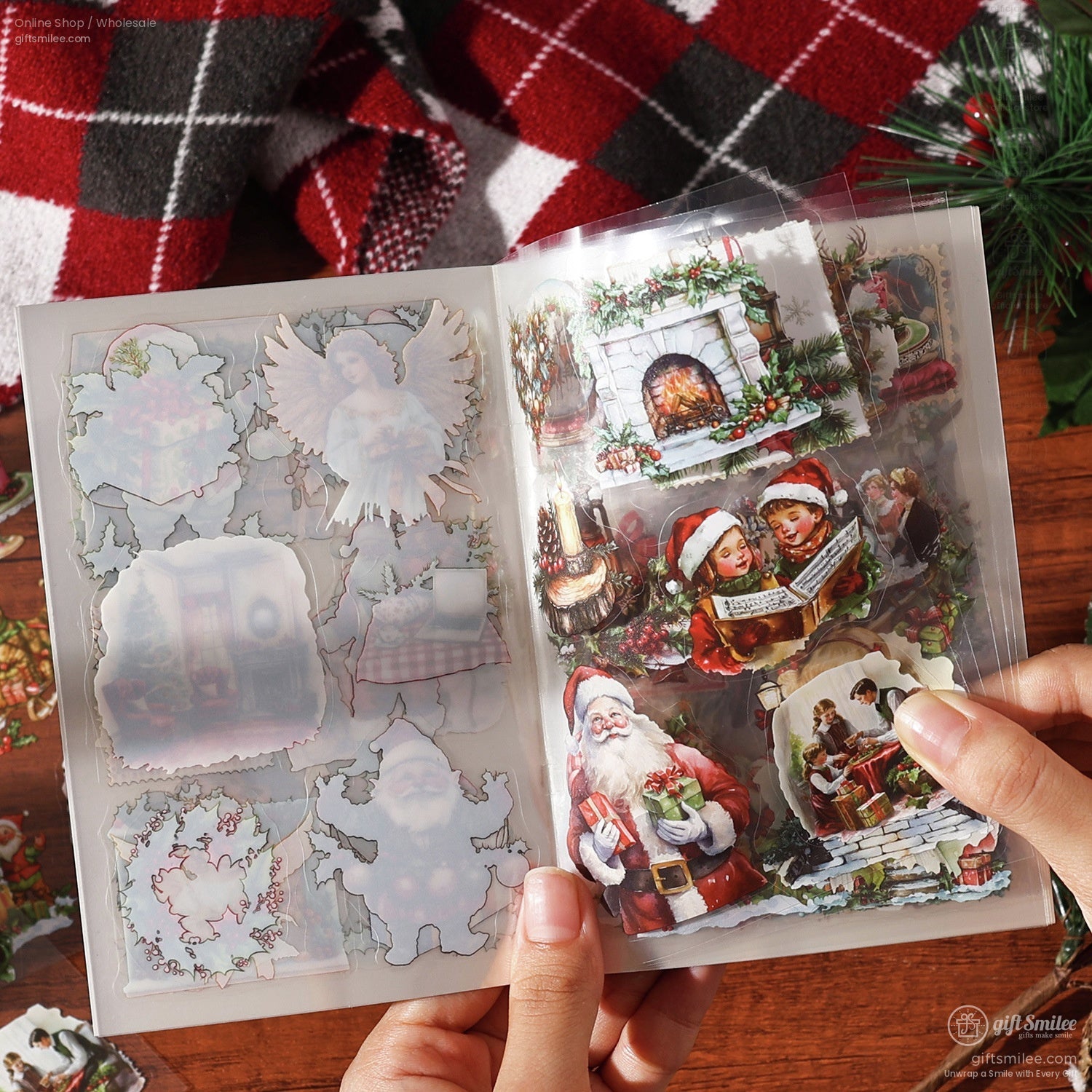 Hands holding an open sticker book with detailed vintage Christmas-themed stickers, featuring Santa, wreaths, and fireplaces
