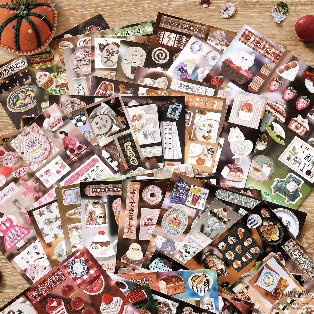 Japanese embroidery sticker book with food and animal designs on a rustic picnic tablecloth