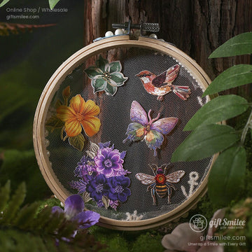 A set of embroidery stickers featuring flowers, butterflies, birds, and a honeybee displayed in a wooden hoop with a forest backdrop