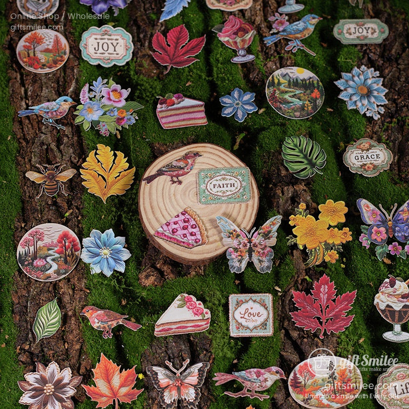 A collection of nature-themed embroidery stickers, including leaves, flowers, birds, and inspirational quotes, spread across a mossy surface