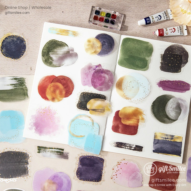 Open journal showcasing vibrant galaxy-themed stickers with paint supplies