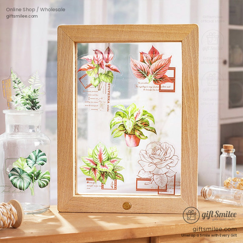 A wooden frame showcasing an assortment of botanical stickers, including flowers and leaves, with a rustic aesthetic