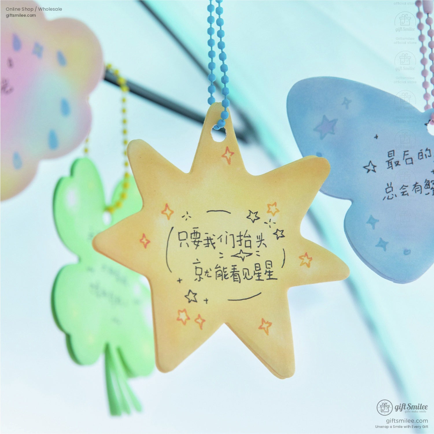 Close-up of a yellow star-shaped sticky note with motivational text and a delicate chain for hanging