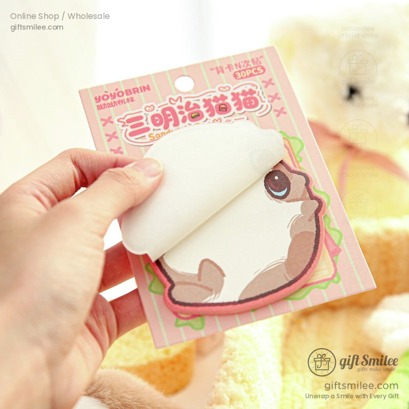 A sandwich-themed cat sticky note being peeled from the pad