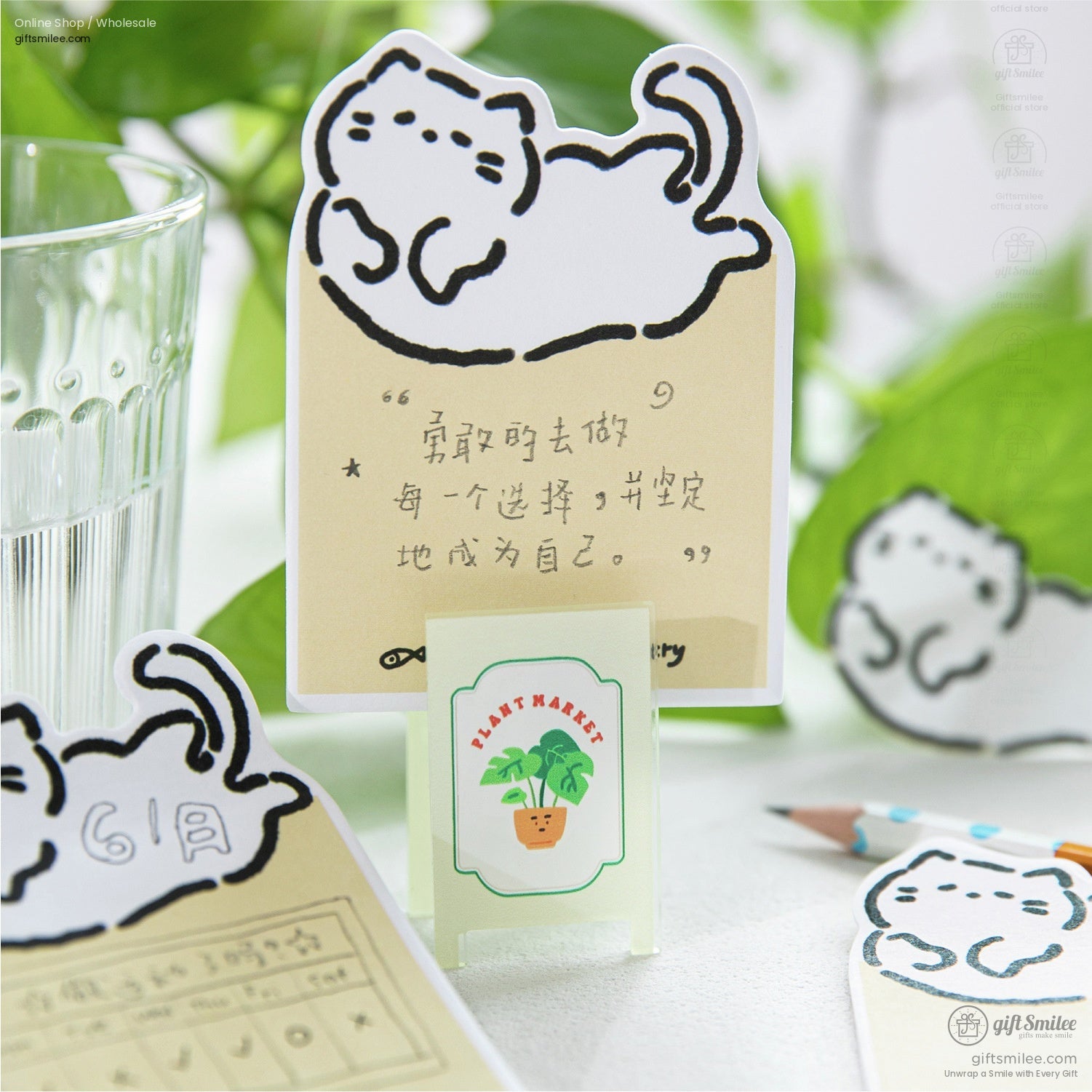 Cute kitten sticky notes with a backdrop of plants and stationery items, great for organizing tasks