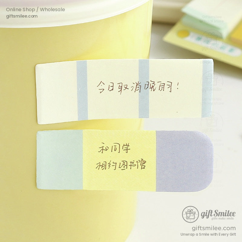 Close-up of pastel sticky notes on a yellow mug, displaying soft and colorful designs
