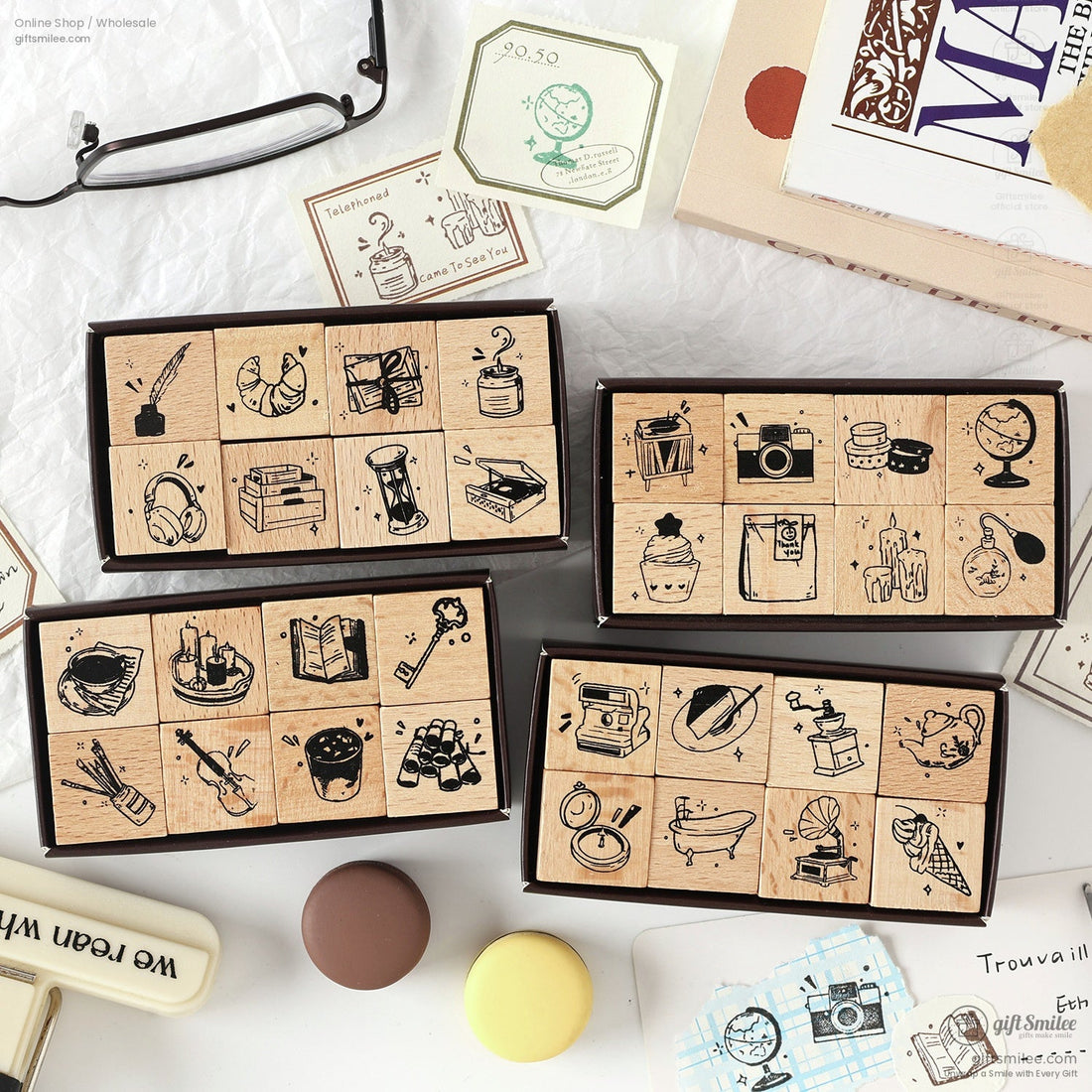 A collection of retro wooden stamps featuring daily life icons like books, globes, and cameras, displayed in elegant packaging