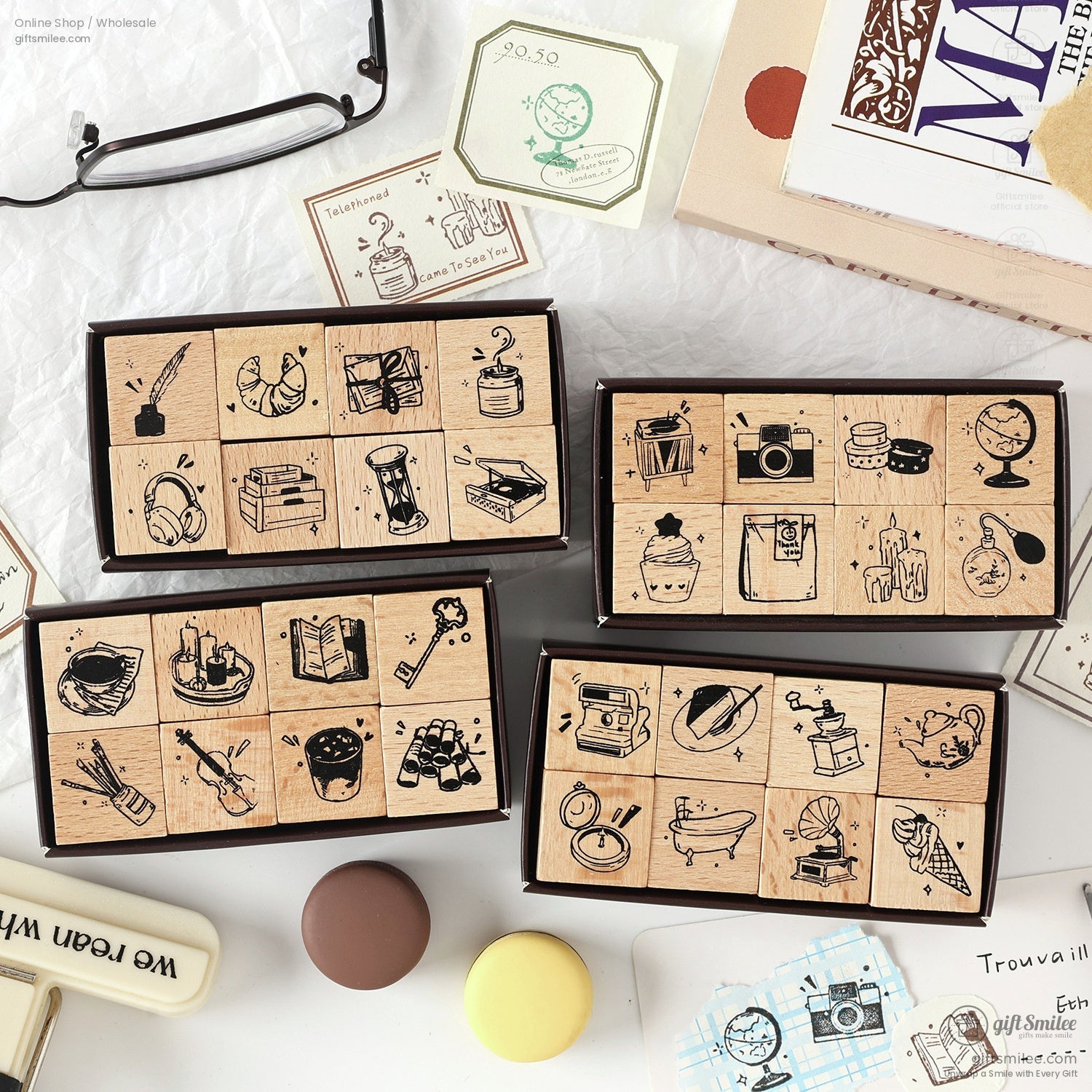 A collection of retro wooden stamps featuring daily life icons like books, globes, and cameras, displayed in elegant packaging
